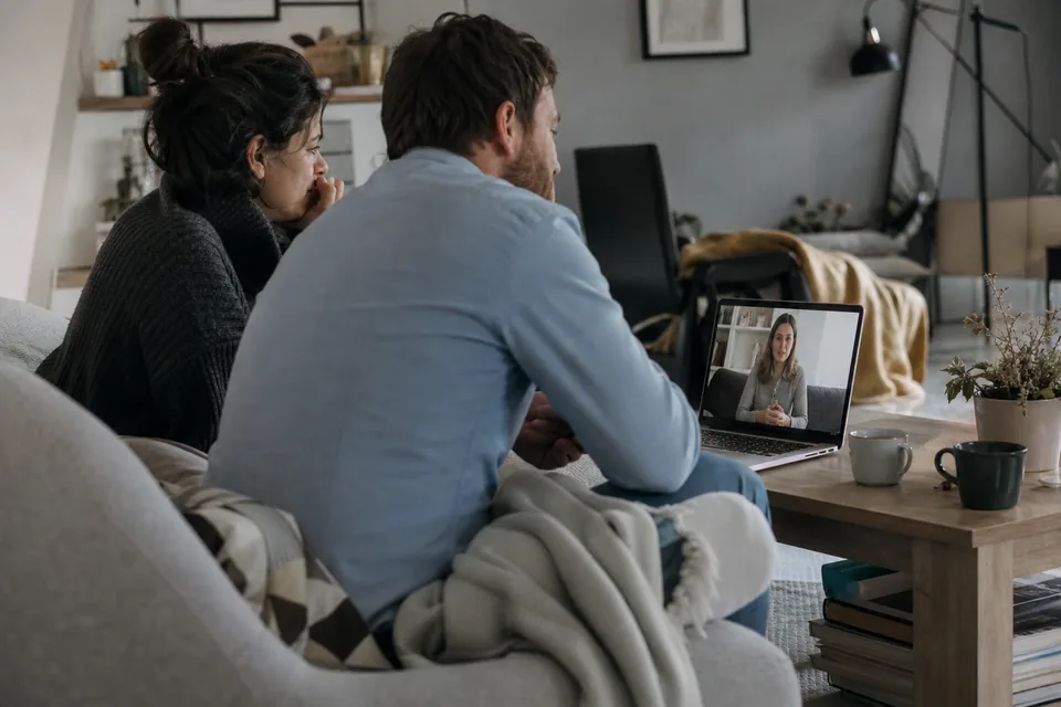 Couple on a laptop video call with a counselor