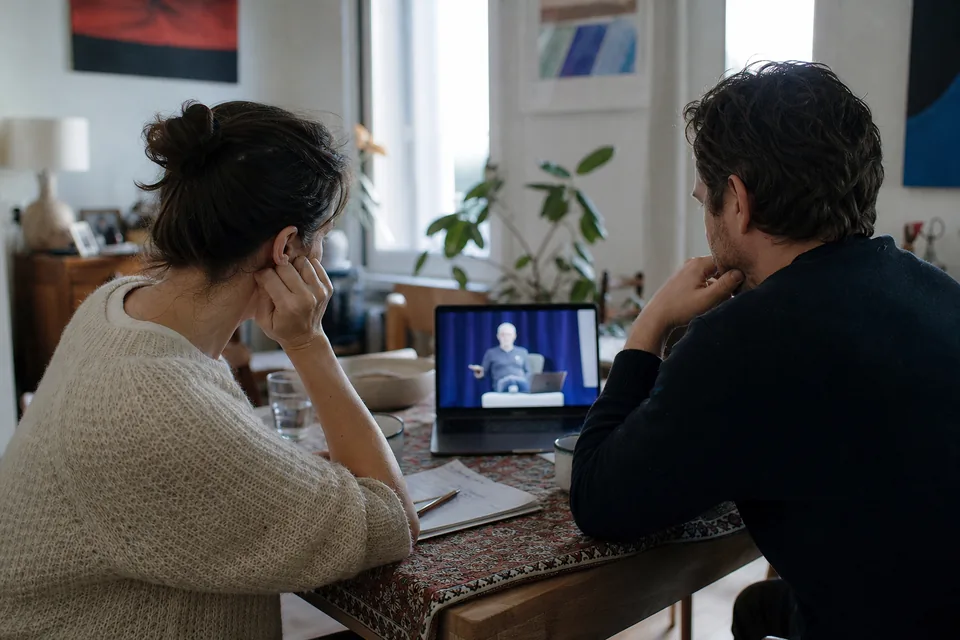 Couple at their dining table following a talk on a laptop, comparing what each option offers